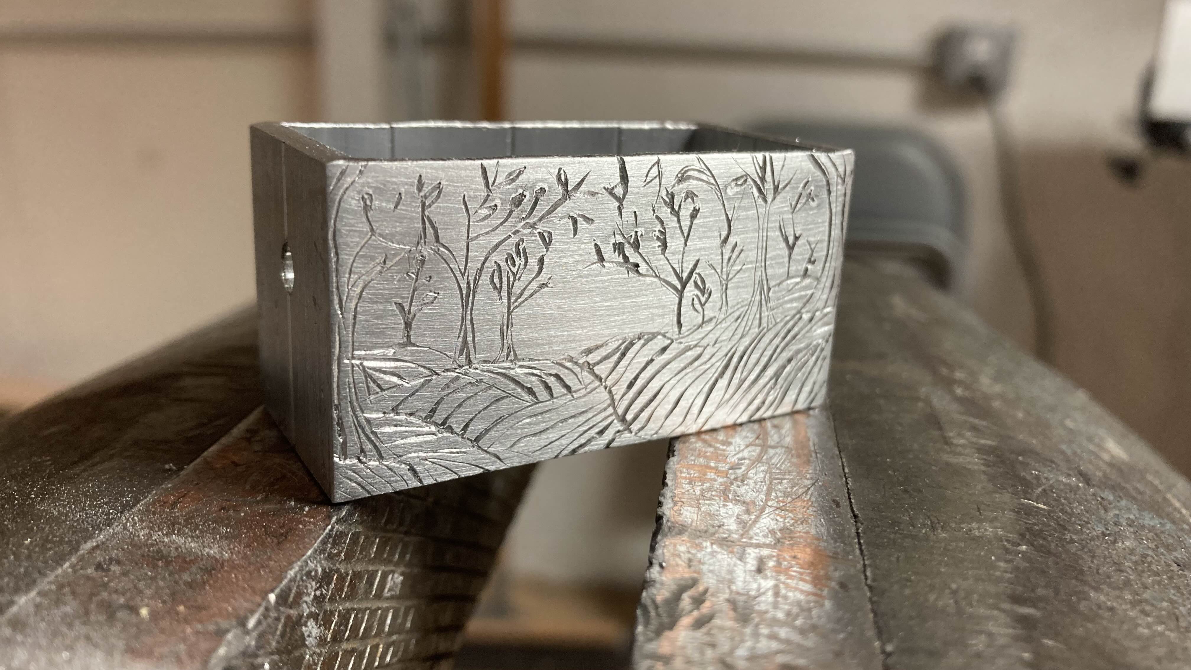An engraving of a forest on aluminum